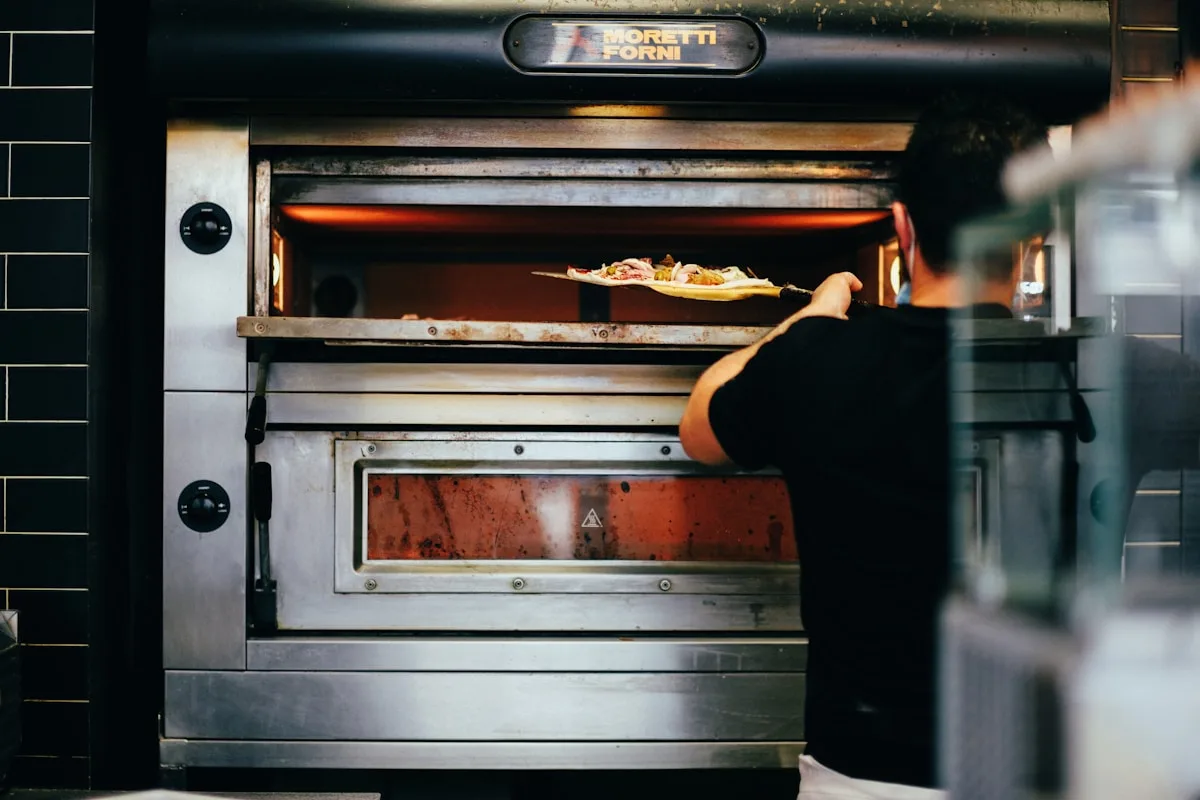 Restaurant chef placing a pizza in the oven